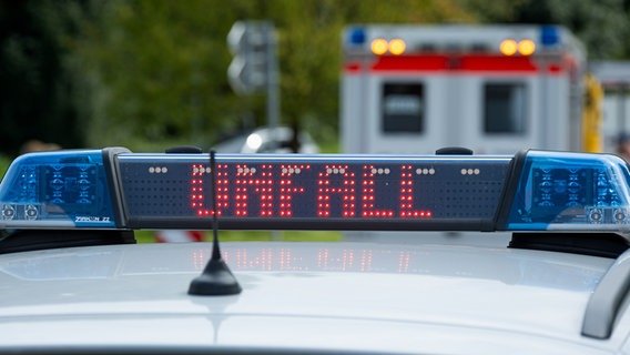 Polizeistreifenwagen mit Blaulicht und dem Schriftzug 'Unfall' im Display an der Unfallstelle. Im Hintergrund sieht man einen Rettungswagen Polizeistreifenwagen mit Blaulicht und dem Schriftzug 'Unfall' im Display an der Unfallstelle. Im Hintergrund sieht man einen Rettungswagen © Picture Alliance Foto: Fotostand/Gelhot