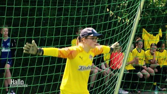 Ein Mädchen steht mit ausgebreiteten Armen im Fußballtor © Screenshot 
